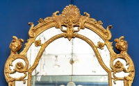 Grand miroir à parclose en bois sculpté et doré. Époque Régence