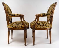 Paire de fauteuils Louis XVI à dossiers médaillons en bois naturel mouluré sculpté et ciré