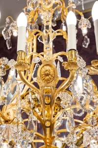 Lustre en bronze doré à 16 bras de lumière et 12 fleurettes en cristal éclairées, XIXème siècle