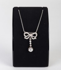 Pendentif en or gris stylisée d&#039;un noeud de ruban serti de diamants 1900