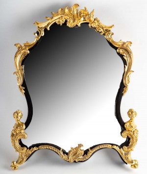 Un miroir mural ou à poser de style Napoléon III en bronze doré et bois noirci.|||||||