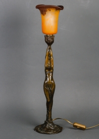 Lampe en bronze patiné représentant une femme retenant une tulipe en pâte de verre.  Époque Art Nouveau vers 1900.  Signée Firmin Bate