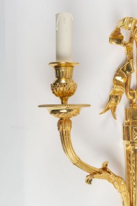 A pair of wall lights in the Louis XVI style.