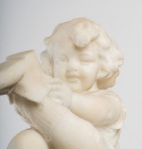 Statue en albâtre représentant une petite fille assise sur un tabouret et jouant avec des chaussures .