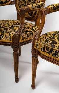 Paire de fauteuils à dossiers médaillons en bois naturel mouluré sculpté et ciré de style Louis XVI