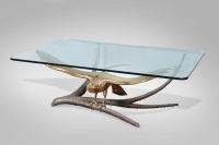 Alain CHERVET (né en 1944) Table basse à plateau en verre rectangulaire, le piètement représentant un aigle en laiton sur une branche en métal torsadé. Signé sur la queue.