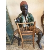 Enfant noir en terre cuite sur une chaise en bambou et cannage. Réf: 356 | Biron ||||||