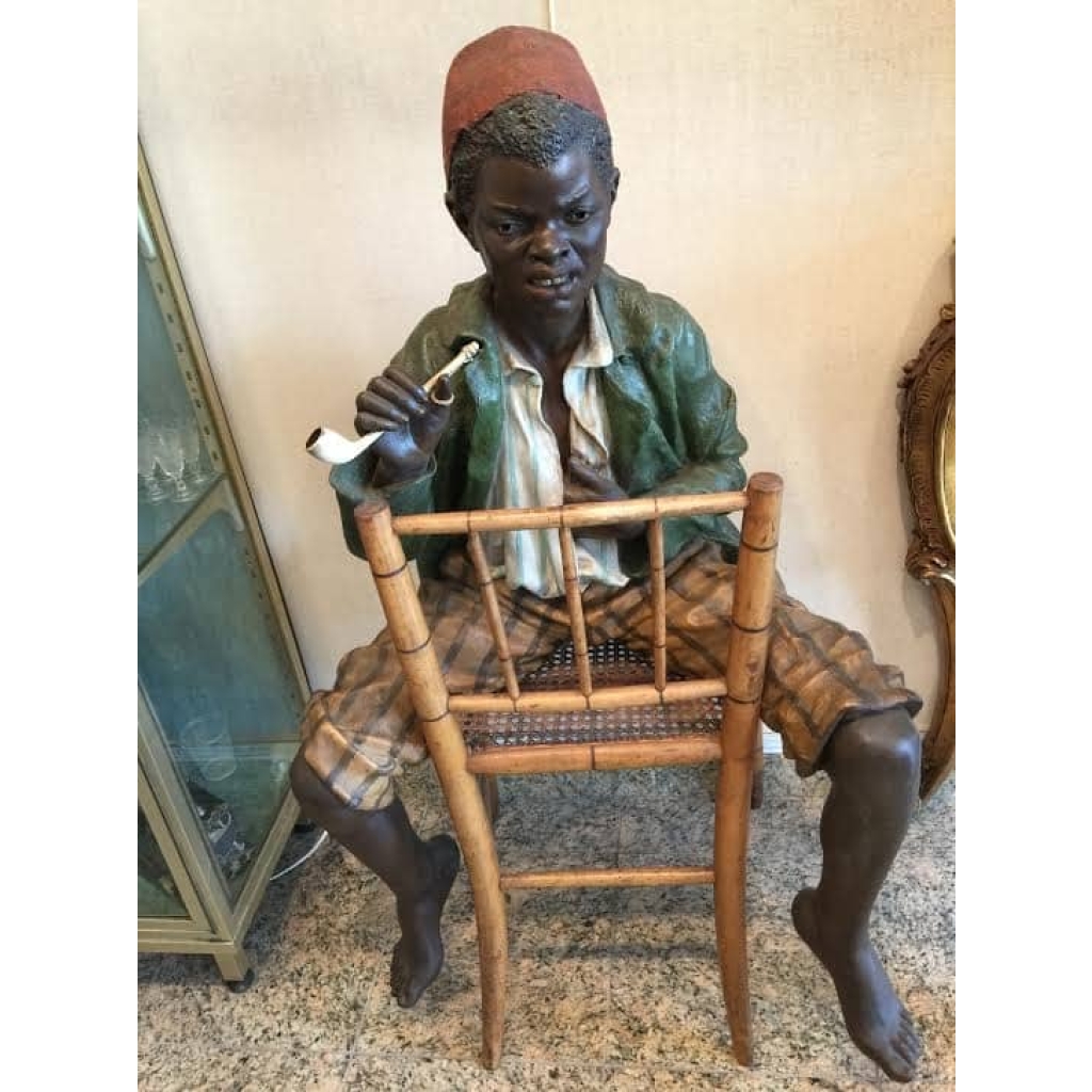 Enfant noir en terre cuite sur une chaise en bambou et cannage. Réf: 356 | Biron ||||||