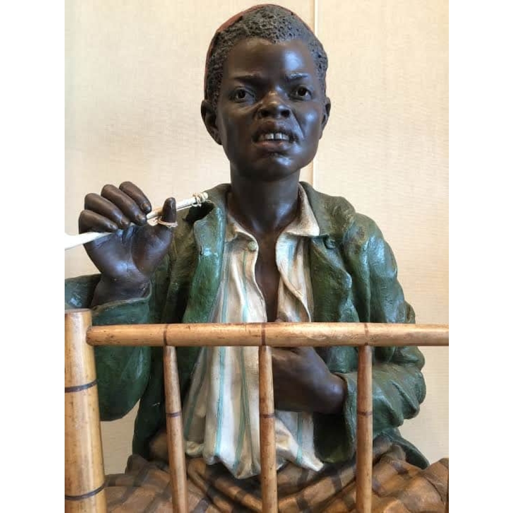 Enfant noir en terre cuite sur une chaise en bambou et cannage. Réf: 356 | Biron Enfant noir en terre cuite sur une chaise en bambou et cannage. Réf: 356