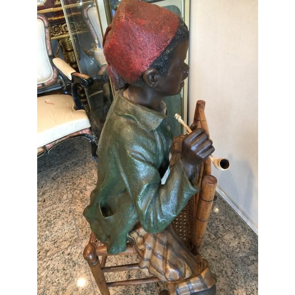 Enfant noir en terre cuite sur une chaise en bambou et cannage. Réf: 356 | Biron Enfant noir en terre cuite sur une chaise en bambou et cannage. Réf: 356