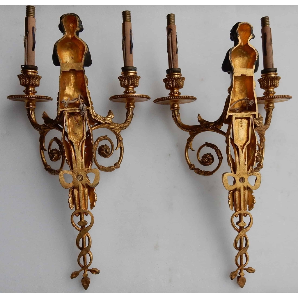 1900′ Paire d Appliques à Deux Bras de Lumière de Style Louis XVI en Bronze Doré d’Après un Modèle de Jean HAURE à Décor de Bustes d’Enfants Musiciens | Biron 1900' Paire d Appliques à Deux Bras de Lumière de Style Louis XVI en Bronze Doré d'Après un Modèle de Jean HAURE à Décor de Bustes d'Enfants Musiciens