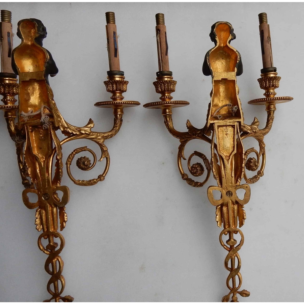 1900′ Paire d Appliques à Deux Bras de Lumière de Style Louis XVI en Bronze Doré d’Après un Modèle de Jean HAURE à Décor de Bustes d’Enfants Musiciens | Biron 1900' Paire d Appliques à Deux Bras de Lumière de Style Louis XVI en Bronze Doré d'Après un Modèle de Jean HAURE à Décor de Bustes d'Enfants Musiciens