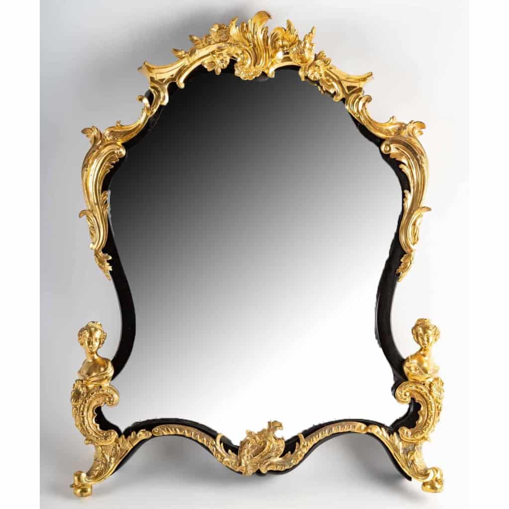 Un miroir mural ou à poser de style Napoléon III en bronze doré et bois noirci. | Biron |||||||