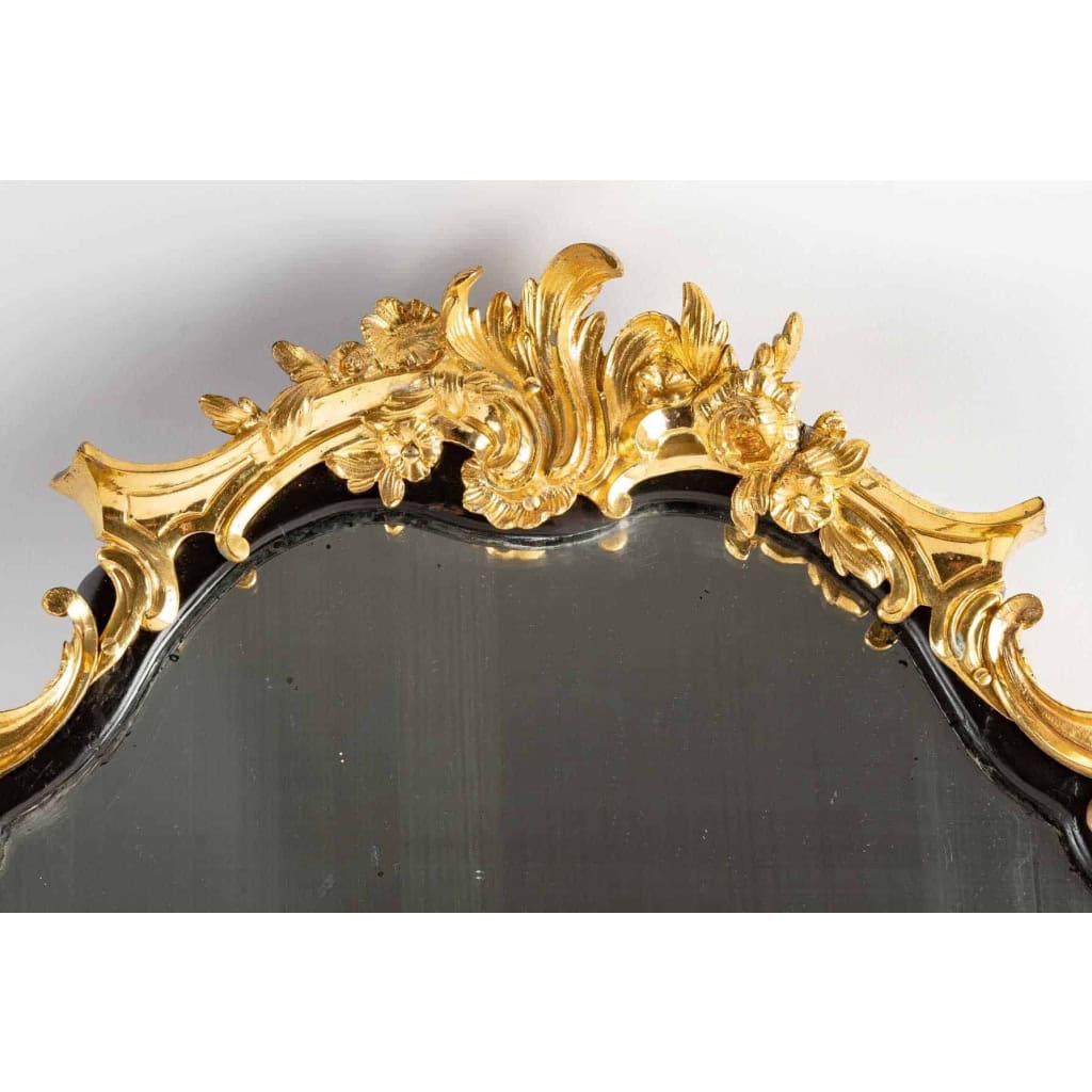 Un miroir mural ou à poser de style Napoléon III en bronze doré et bois noirci. | Biron Un miroir mural ou à poser de style Napoléon III en bronze doré et bois noirci.