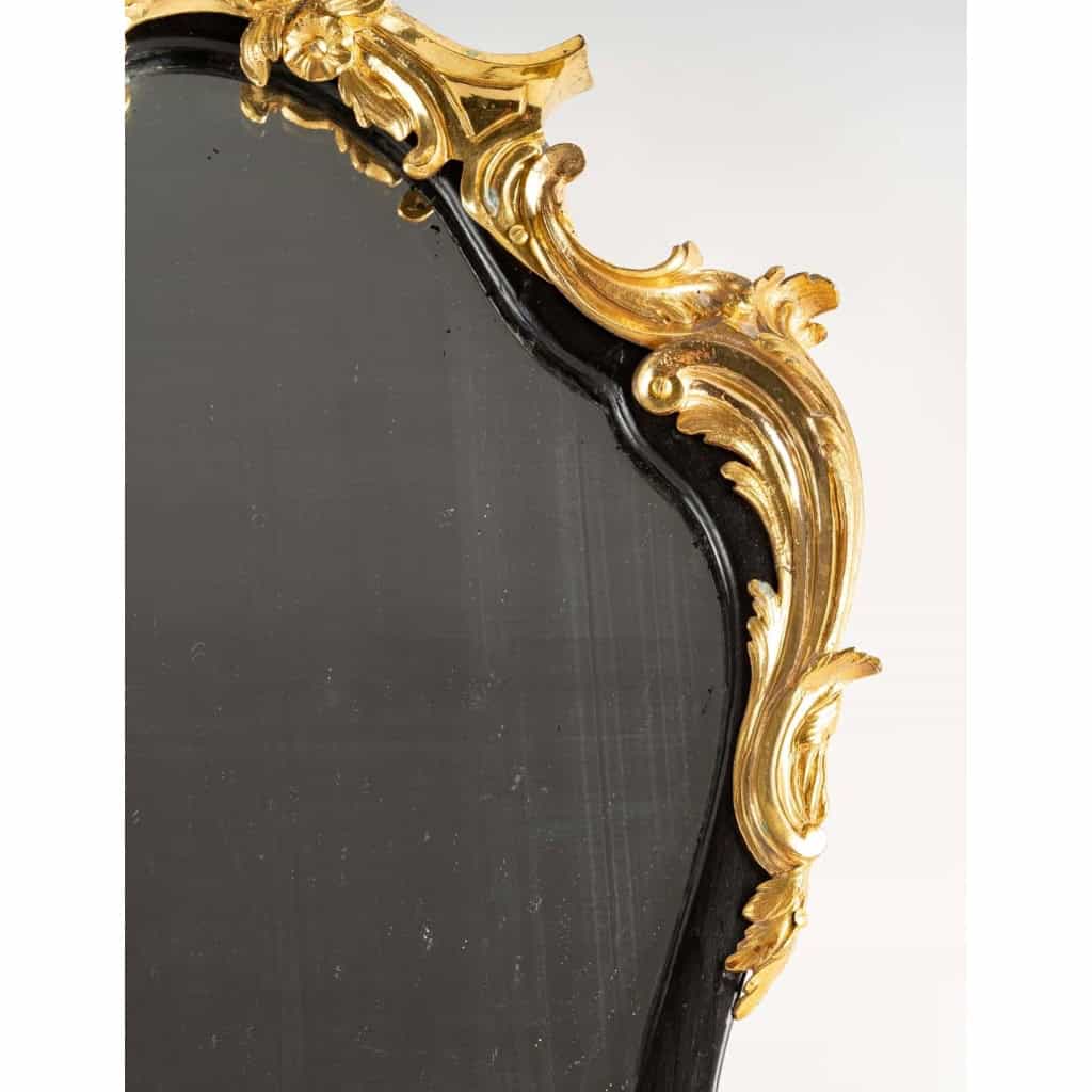 Un miroir mural ou à poser de style Napoléon III en bronze doré et bois noirci. | Biron Un miroir mural ou à poser de style Napoléon III en bronze doré et bois noirci.