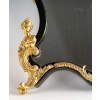 Un miroir mural ou à poser de style Napoléon III en bronze doré et bois noirci. | Biron Un miroir mural ou à poser de style Napoléon III en bronze doré et bois noirci.