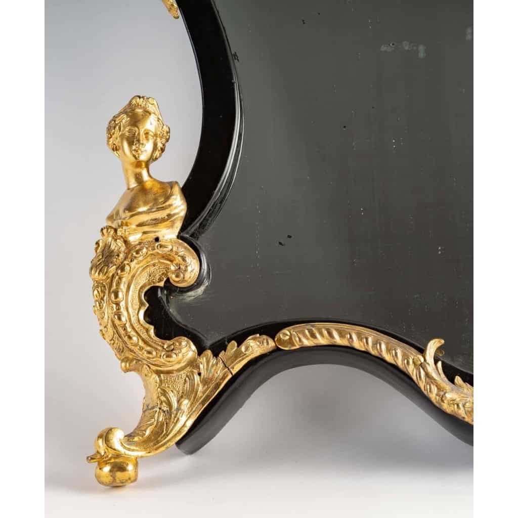 Un miroir mural ou à poser de style Napoléon III en bronze doré et bois noirci. | Biron Un miroir mural ou à poser de style Napoléon III en bronze doré et bois noirci.