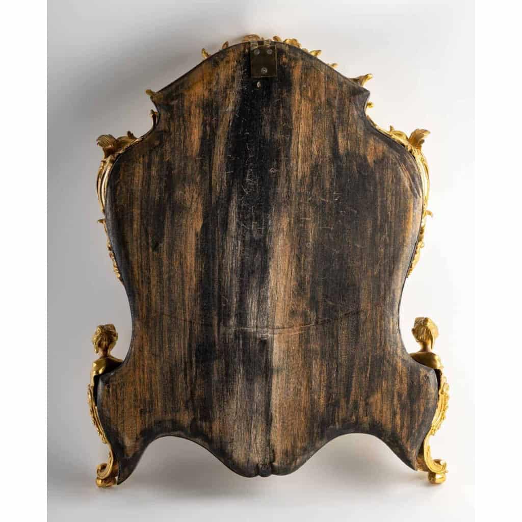 Un miroir mural ou à poser de style Napoléon III en bronze doré et bois noirci. | Biron Un miroir mural ou à poser de style Napoléon III en bronze doré et bois noirci.