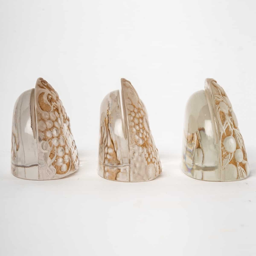 Suite de 9 Porte-Menus verre blanc patiné sépia de René LALIQUE | Biron Suite de 9 Porte-Menus verre blanc patiné sépia de René LALIQUE