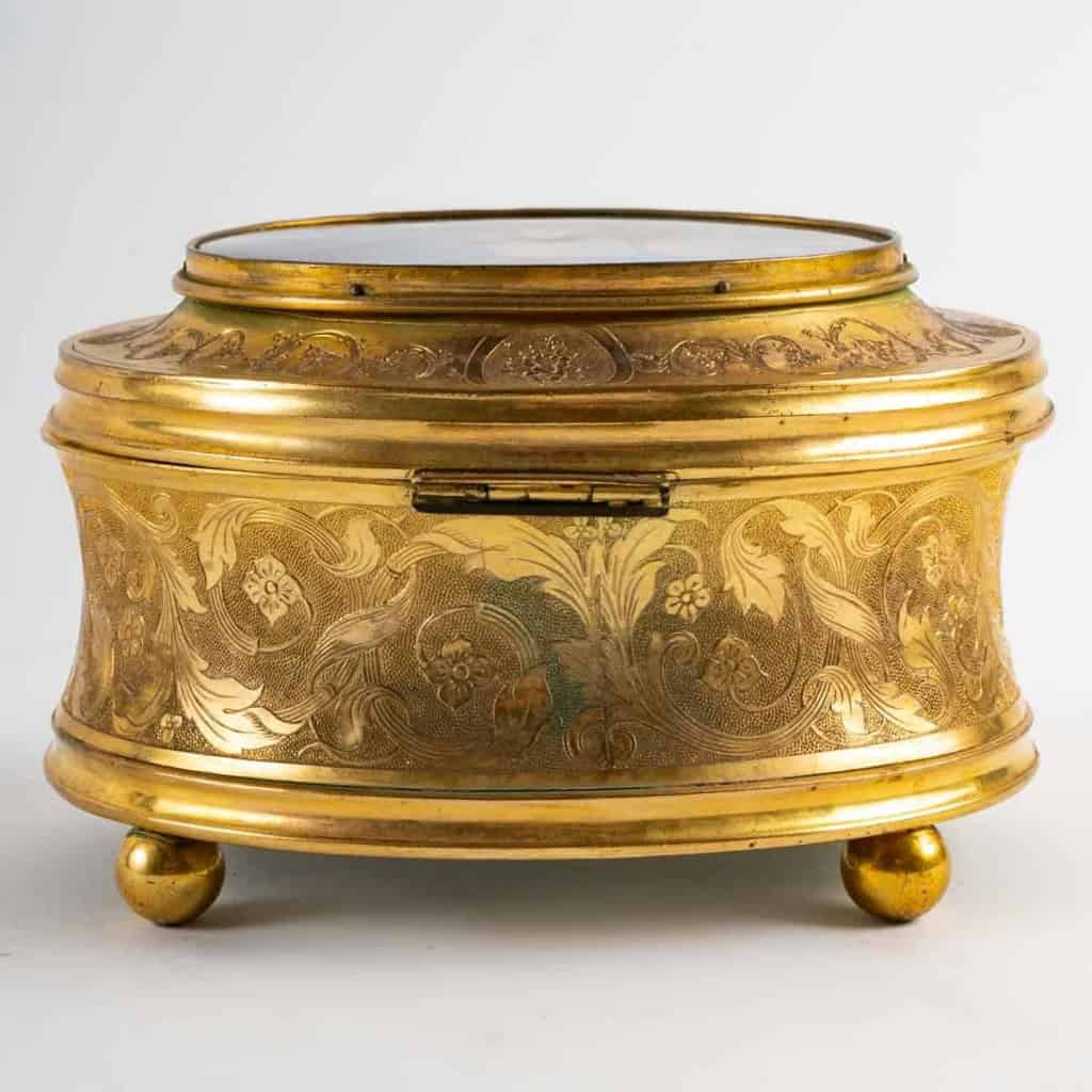 Boite à bijoux en bronze doré, comportant une marine en fixé sous verre, XIXe siècle. | Biron Boite à bijoux en bronze doré, comportant une marine en fixé sous verre, XIXe siècle.