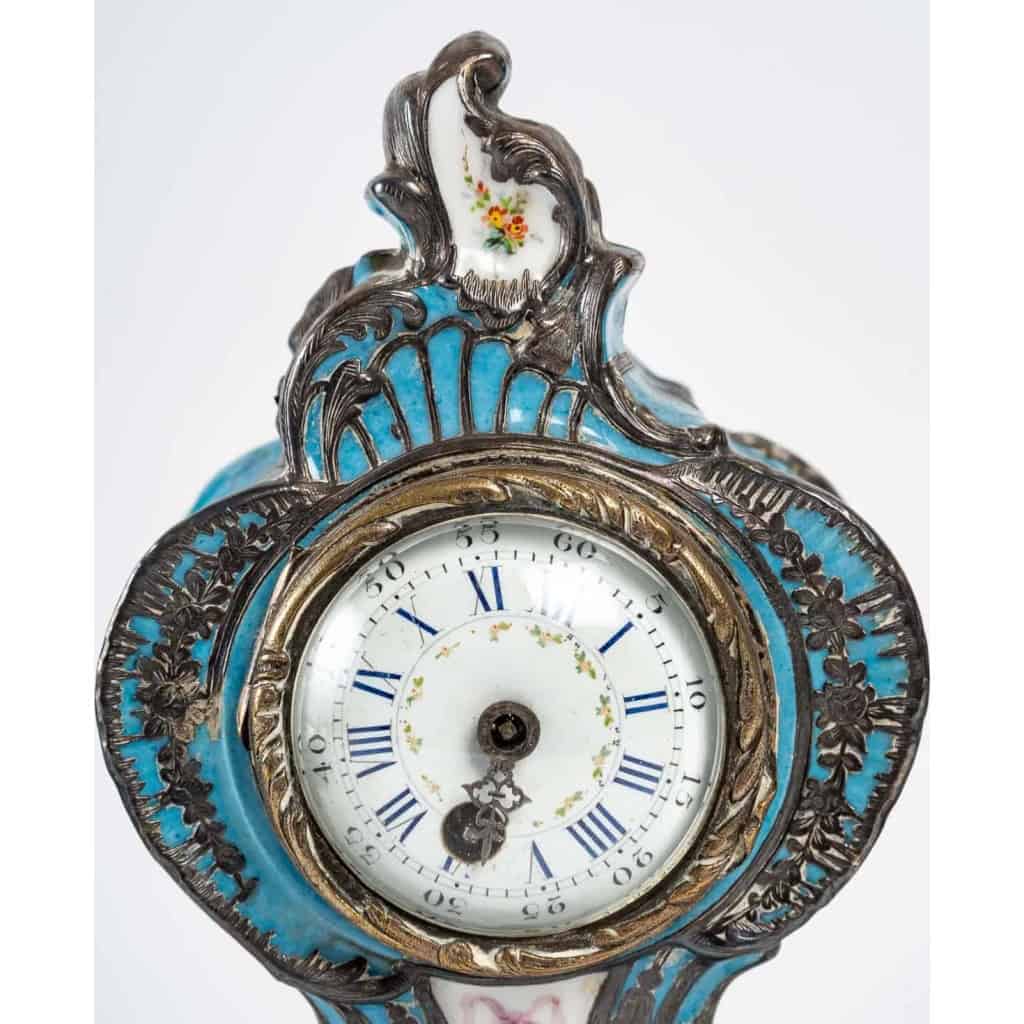 Rare pendule en porcelaine émaillée en argent et une paire de coupe en opaline blanche, XIXème siècle | Biron Rare pendule en porcelaine émaillée en argent et une paire de coupe en opaline blanche, XIXème siècle