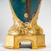 Vase en grès flammé à décor de coulures, sur socle en bronze à patine dorée, signé Paul Louchet, début XXe siècle. | Biron Vase en grès flammé à décor de coulures, sur socle en bronze à patine dorée, signé Paul Louchet, début XXe siècle.
