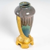 Vase en grès flammé à décor de coulures, sur socle en bronze à patine dorée, signé Paul Louchet, début XXe siècle. | Biron Vase en grès flammé à décor de coulures, sur socle en bronze à patine dorée, signé Paul Louchet, début XXe siècle.