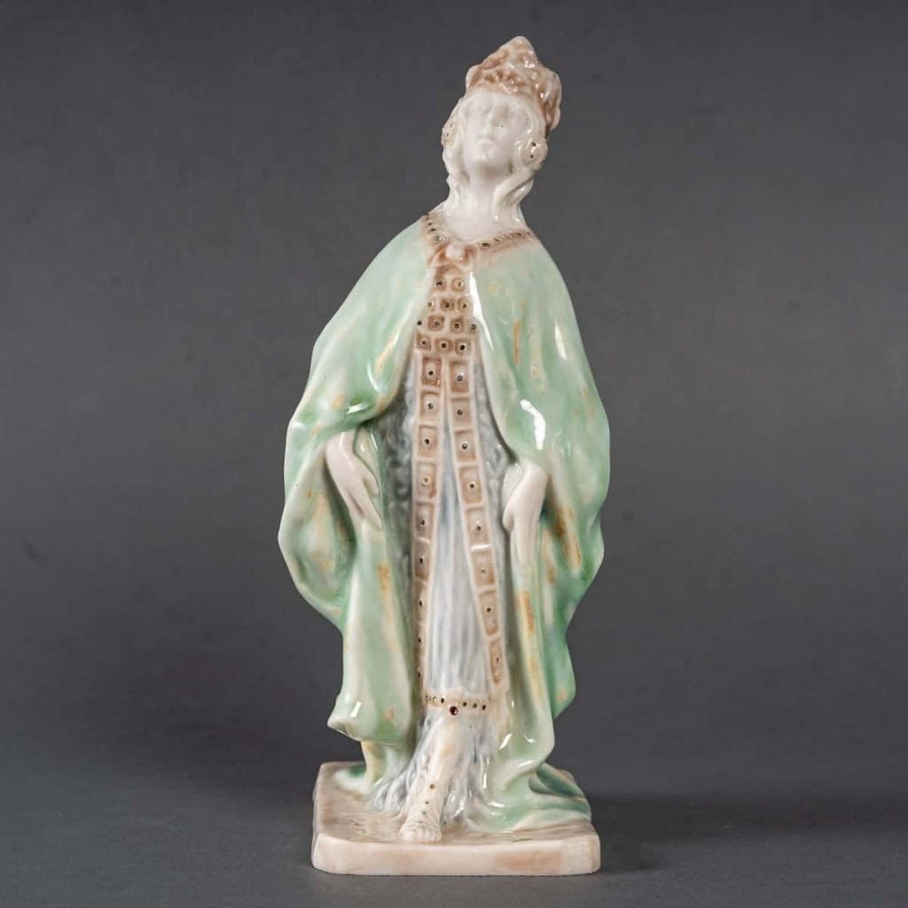 Statuette en porcelaine à couverte émaillée blanc et turquoise, intitulée « Princesse Irène », signée Mougin, Nancy, début du XXe siècle. | Biron Statuette en porcelaine à couverte émaillée blanc et turquoise, intitulée "Princesse Irène", signée Mougin, Nancy, début du XXe siècle.