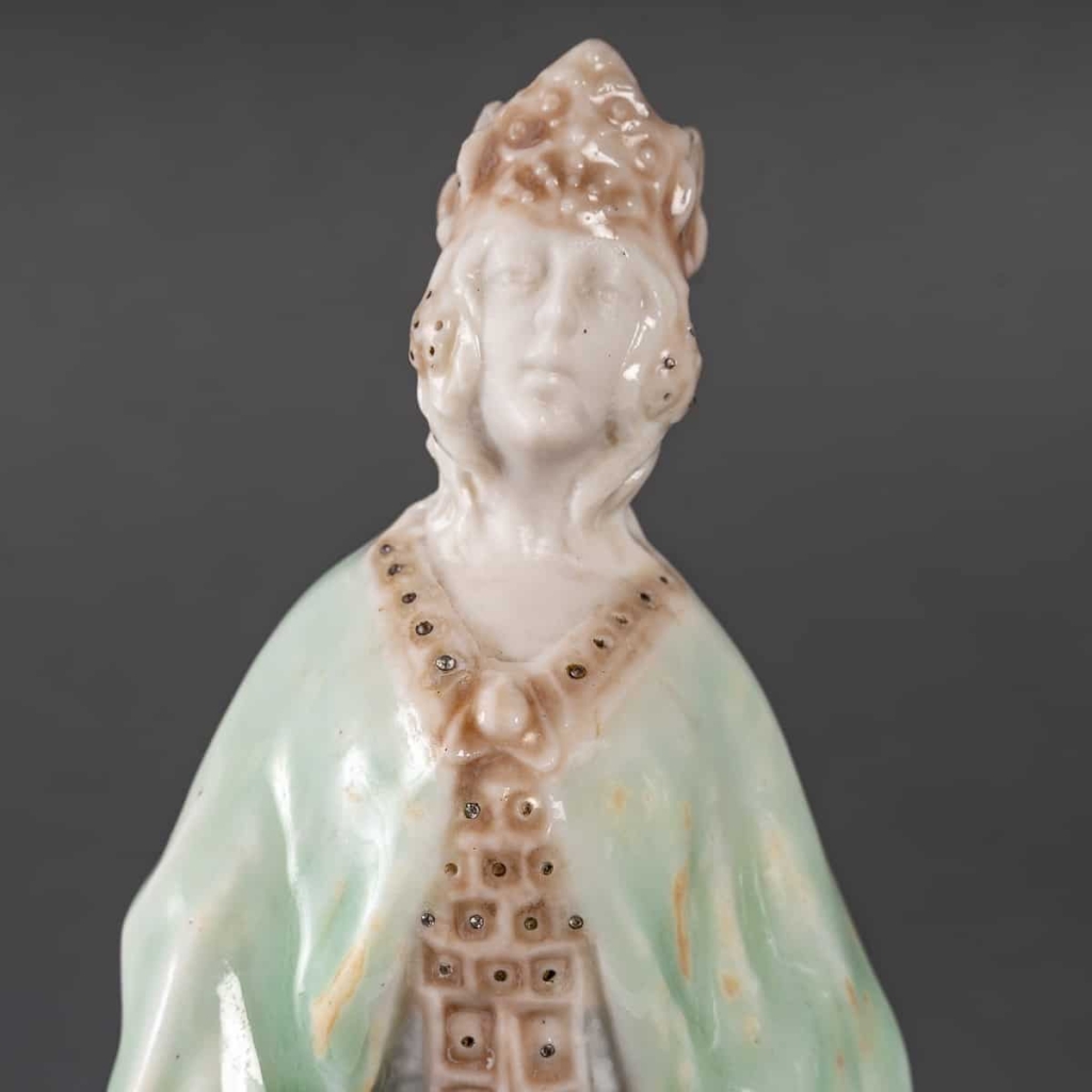 Statuette en porcelaine à couverte émaillée blanc et turquoise, intitulée « Princesse Irène », signée Mougin, Nancy, début du XXe siècle. | Biron Statuette en porcelaine à couverte émaillée blanc et turquoise, intitulée "Princesse Irène", signée Mougin, Nancy, début du XXe siècle.