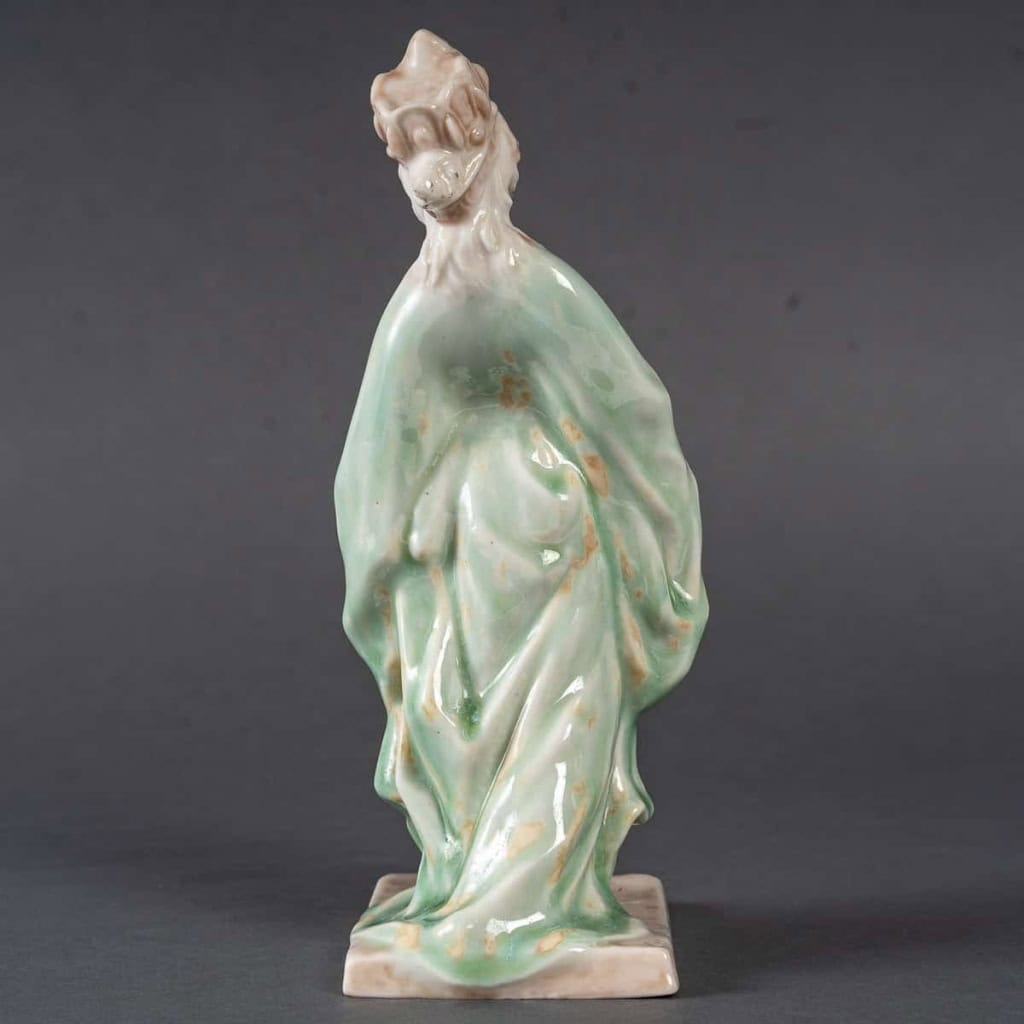 Statuette en porcelaine à couverte émaillée blanc et turquoise, intitulée « Princesse Irène », signée Mougin, Nancy, début du XXe siècle. | Biron Statuette en porcelaine à couverte émaillée blanc et turquoise, intitulée "Princesse Irène", signée Mougin, Nancy, début du XXe siècle.