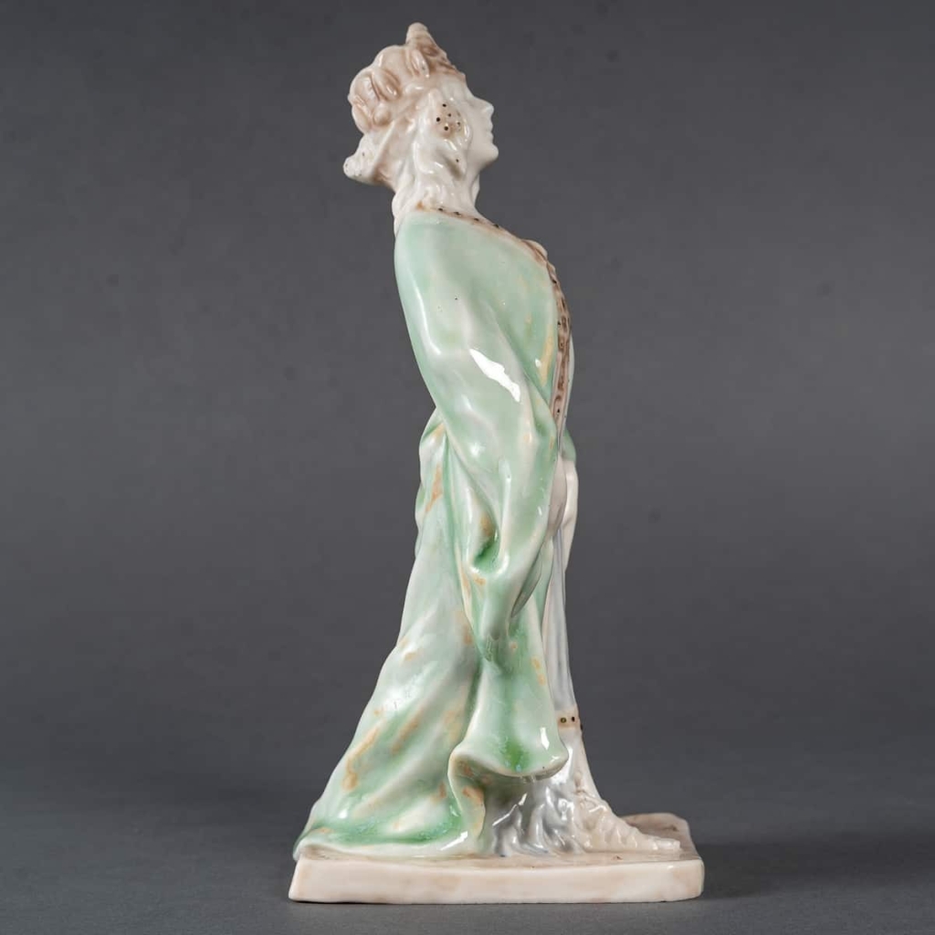 Statuette en porcelaine à couverte émaillée blanc et turquoise, intitulée « Princesse Irène », signée Mougin, Nancy, début du XXe siècle. | Biron Statuette en porcelaine à couverte émaillée blanc et turquoise, intitulée "Princesse Irène", signée Mougin, Nancy, début du XXe siècle.