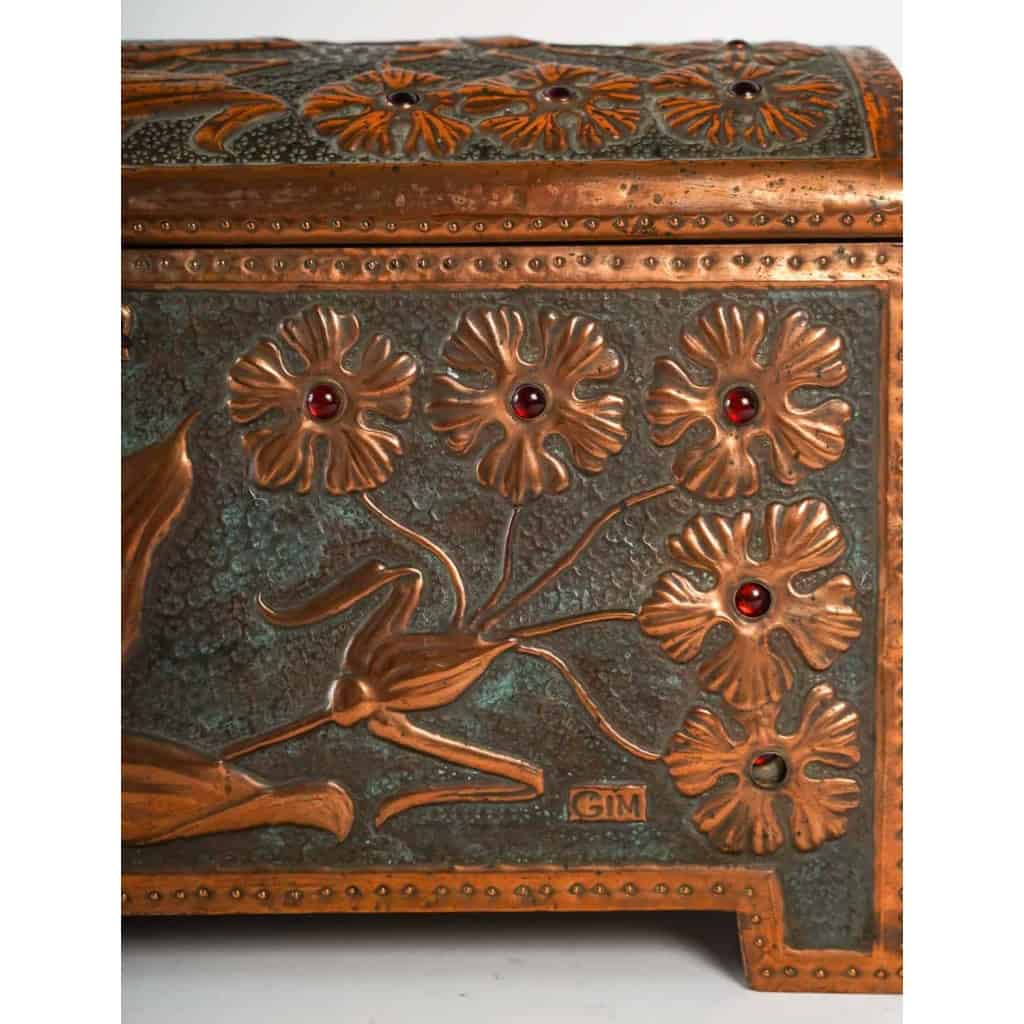  Coffret Art Nouveau en cuivre repoussé sur âme de bois, serti de cabochons de verre à décor de fleurs et libellule, signé « GIM », début du XXe siècle. | Biron  Coffret Art Nouveau en cuivre repoussé sur âme de bois, serti de cabochons de verre à décor de fleurs et libellule, signé "GIM", début du XXe siècle.