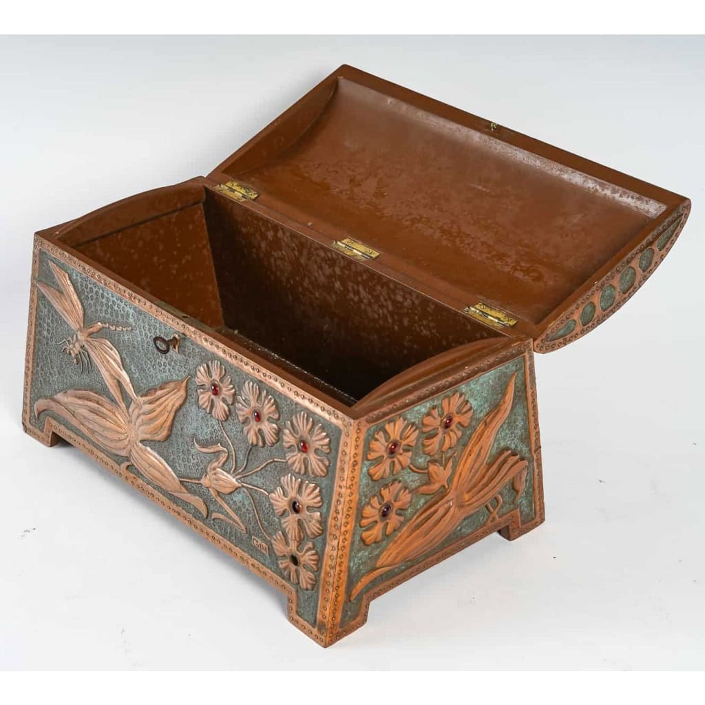  Coffret Art Nouveau en cuivre repoussé sur âme de bois, serti de cabochons de verre à décor de fleurs et libellule, signé « GIM », début du XXe siècle. | Biron  Coffret Art Nouveau en cuivre repoussé sur âme de bois, serti de cabochons de verre à décor de fleurs et libellule, signé "GIM", début du XXe siècle.