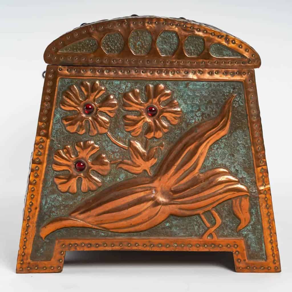  Coffret Art Nouveau en cuivre repoussé sur âme de bois, serti de cabochons de verre à décor de fleurs et libellule, signé « GIM », début du XXe siècle. | Biron  Coffret Art Nouveau en cuivre repoussé sur âme de bois, serti de cabochons de verre à décor de fleurs et libellule, signé "GIM", début du XXe siècle.