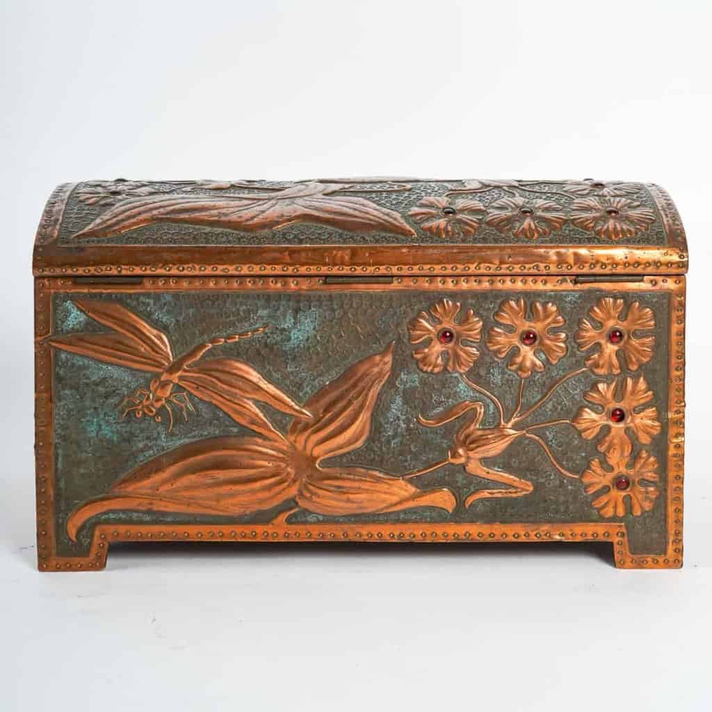  Coffret Art Nouveau en cuivre repoussé sur âme de bois, serti de cabochons de verre à décor de fleurs et libellule, signé « GIM », début du XXe siècle. | Biron  Coffret Art Nouveau en cuivre repoussé sur âme de bois, serti de cabochons de verre à décor de fleurs et libellule, signé "GIM", début du XXe siècle.