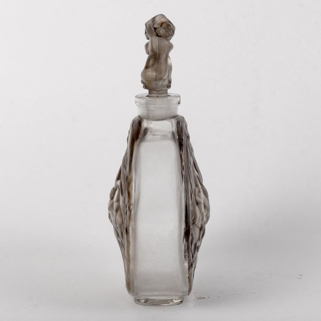 Flacon « Rosace Figurines » verre blanc patiné gris de René LALIQUE | Biron Flacon « Rosace Figurines » verre blanc patiné gris de René LALIQUE