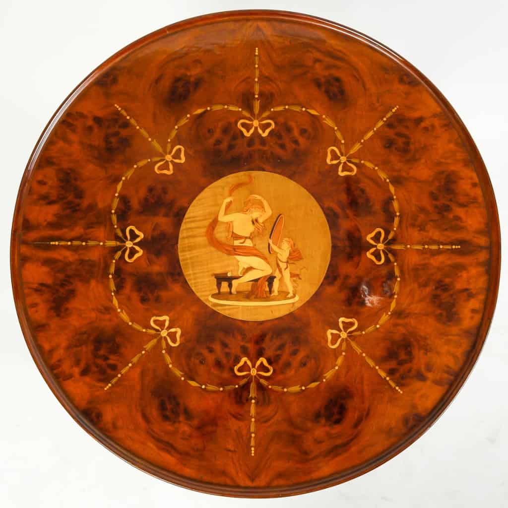 Table ronde ouvrant par un tiroir en marqueterie de bois précieux. Plateau finement marqueté d’une scène d’après l’Antique | Biron Table ronde ouvrant par un tiroir en marqueterie de bois précieux. Plateau finement marqueté d'une scène d'après l'Antique