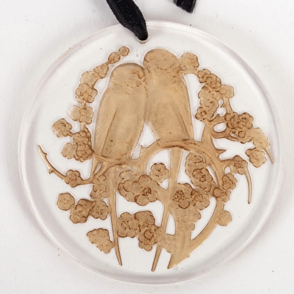 Pendentif « Deux Perruches » verre blanc patiné sépia de René LALIQUE | Biron Pendentif "Deux Perruches" verre blanc patiné sépia de René LALIQUE