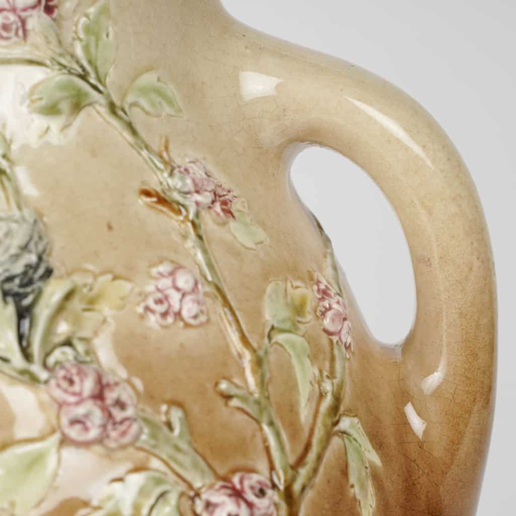Vase en barbotine à décor en pâte sur pâte de putti et fleurs, signé Carrier-Belleuse pour la faïencerie de Choisy Le Roi, circa 1890 | Biron Vase en barbotine à décor en pâte sur pâte de putti et fleurs, signé Carrier-Belleuse pour la faïencerie de Choisy Le Roi, circa 1890