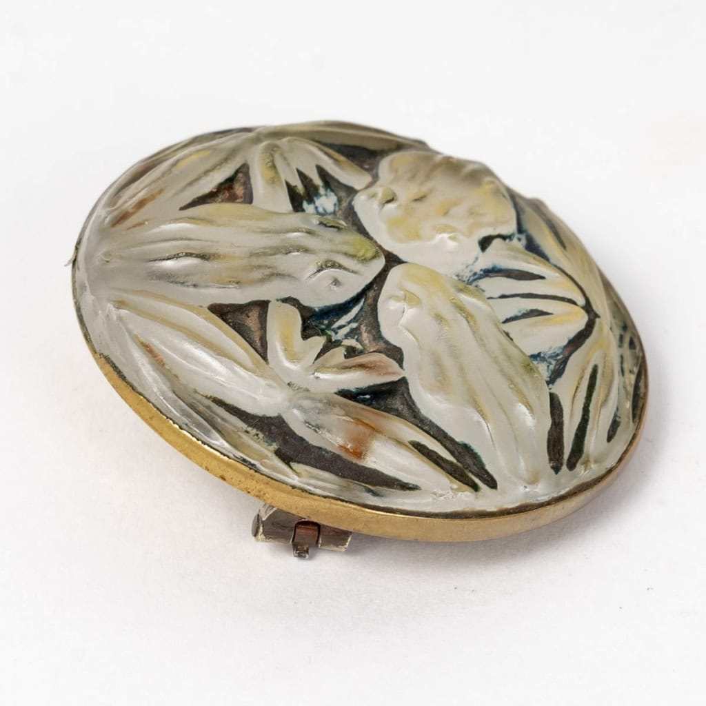 Broche « Grenouilles » verre blanc patiné vert foncé sur clinquant jaune de René LALIQUE | Biron Broche "Grenouilles" verre blanc patiné vert foncé sur clinquant jaune de René LALIQUE