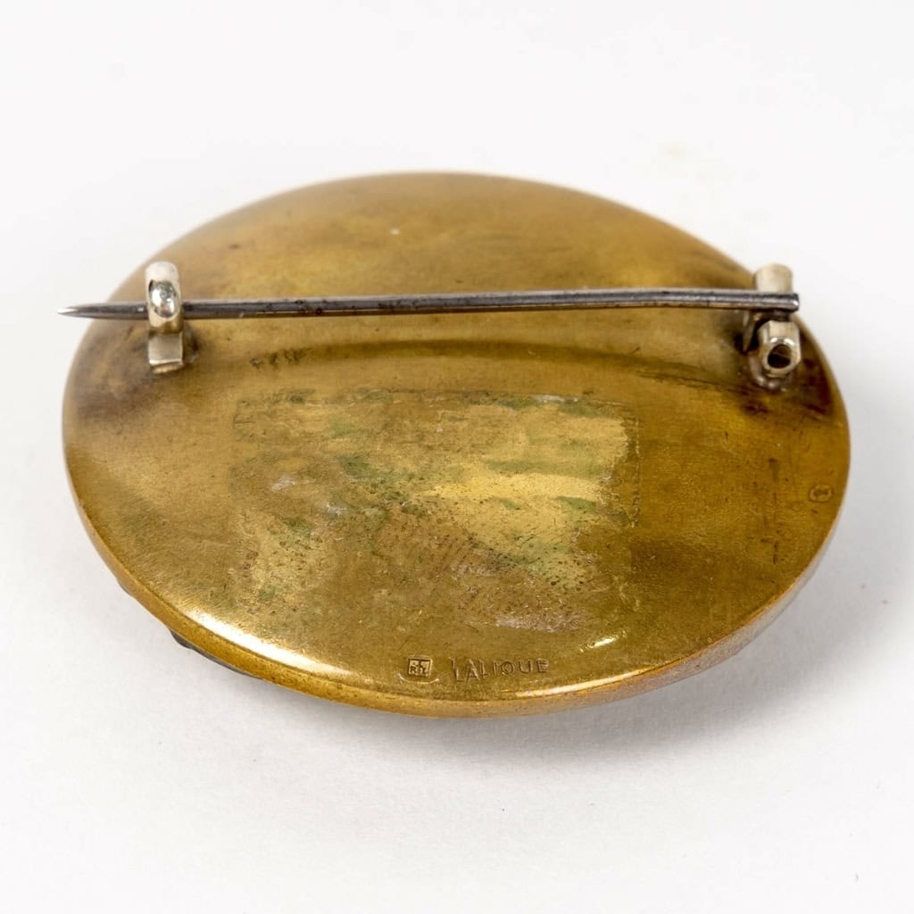 Broche « Grenouilles » verre blanc patiné vert foncé sur clinquant jaune de René LALIQUE | Biron Broche "Grenouilles" verre blanc patiné vert foncé sur clinquant jaune de René LALIQUE