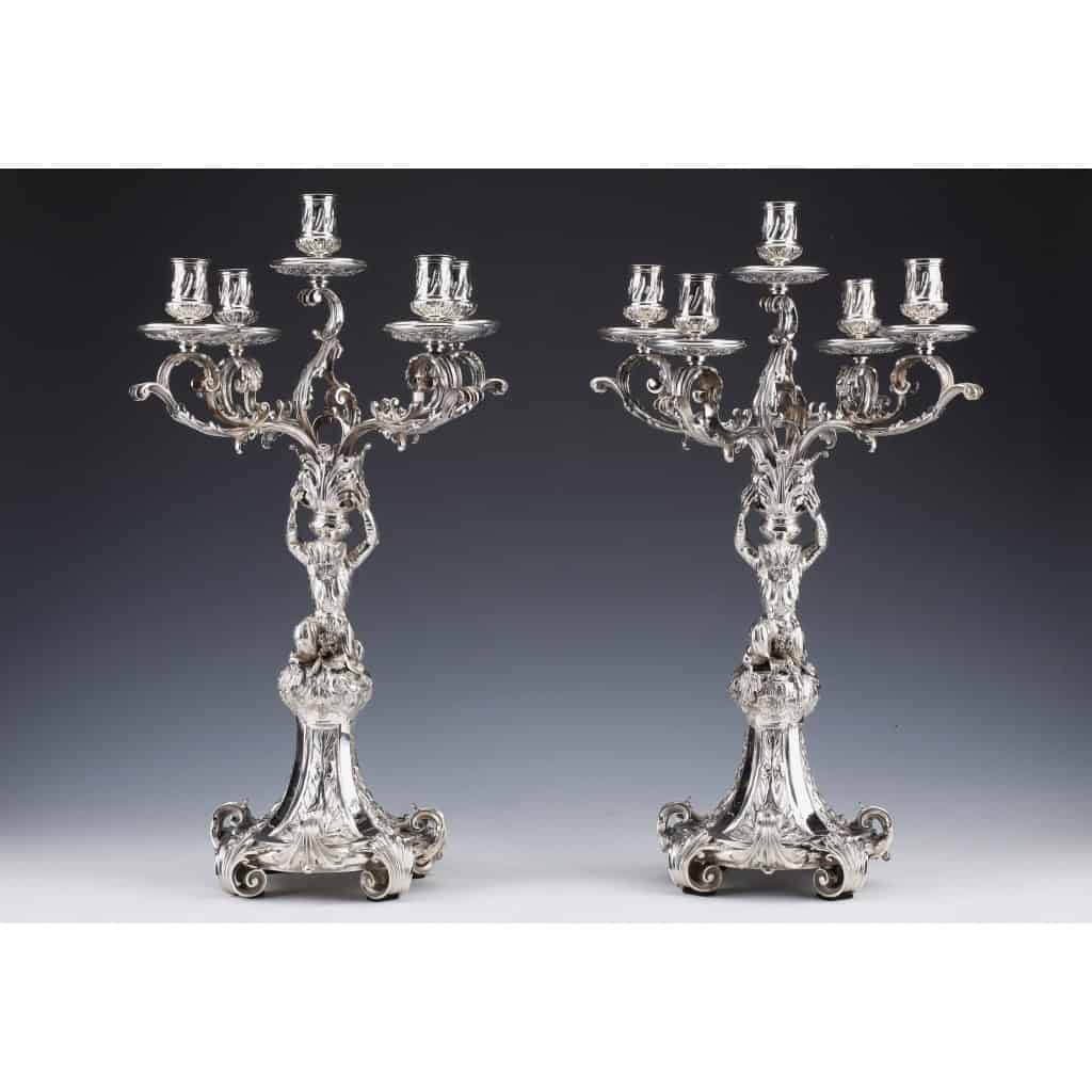ORFEVRE MERITE – Paire de candélabres en argent massif XIXe | Biron ORFEVRE MERITE - Paire de candélabres en argent massif XIXeImportante paire de candélabres à cinq bras de lumière en argent massif décor feuillagés. Le bouquet central est supporté par un singe debout sur une base circulaire décorée de roseaux et végétaux dans des réserves. Dimensions : hauteur 53 cm – largeur 34 cm – diamètre base 20 cm Matière : Argent 1er titre 950/°°° Poids : 7275 grammes Poinçon : MINERVE Epoque : Seconde partie du XIXe siècle Orfèvre : MERITE à PARIS Origine : France/Paris