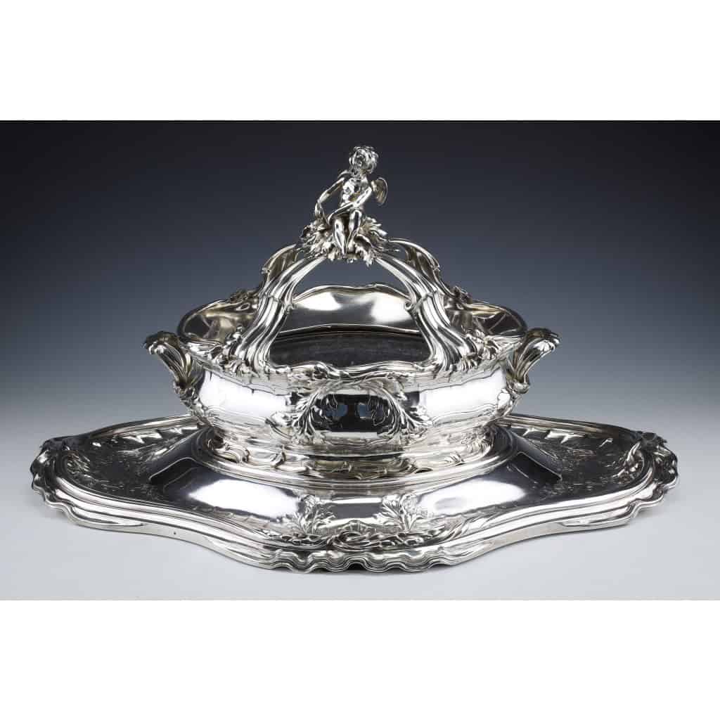 ORFEVRES Risler & Carré – Important centre de table en argent massif XIXe siècle | Biron RISLER & CARRE - Important centre de table en argent massif XIXè siècle Important centre de table en argent massif en deux parties formé par un plateau décoré de vagues et une jardinière surmontée d'un putti, à décor de coquillages et crustacés. Dimensions : plateau 73 cm x 47 cm Jardinière ; 47 cm x 30 cm haut 36 cm Matière : Argent 1er titre 950/°°° Poids : 12794 grammes Poinçon : MINERVE Epoque : XIXème Orfèvre : RISLER & CARRE Origine : FRANCE/PARIS