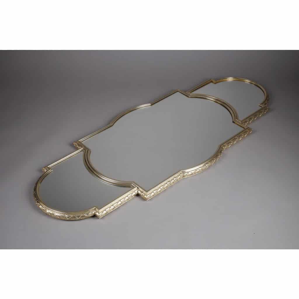 ORFEVRE TETARD – Centre de table 3 parties et sa jardinière en vermeil XIXème | Biron TETARD - Surtout de table 3 parties et sa Jardinière en vermeil XIXè Important surtout de table en trois parties de style Louis XVI, à fond de miroirs, sur un parquet de bois, serti d'une forte lingotière en vermeil ciselée de lauriers. Sa Jardinière à décor de balustrades et de feuilles de laurier, posée au centre, épouse les formes du surtout. Intérieur en métal Dimensions : longueur totale 128 cm Milieu : 76 cm x 52 cm x 3 cm 1/2 cotés : 26 cm x 37 cm Jardinière : 48 cm x 31 cm x 8 cm approximatif Matière : argent 1er titre 950/°°° Poids : Poinçon : MINERVE Epoque : XIXè NAPOLEON III Orfèvre : TETARD à PARIS Origine : France/Paris