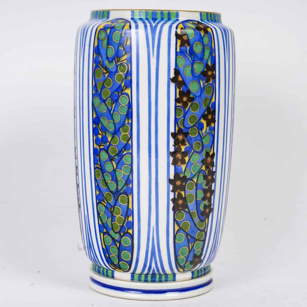 Très élégant vase en porcelaine blanche à décor abstrait végétalisant géométriques dans les tons de bleu, vert, noir, jaune et rouge. Pièce signée, au cachet de la Manufacture National de Sèvres, décor peint d’après l’artiste Jane Levy, travail de 1925. | Biron 