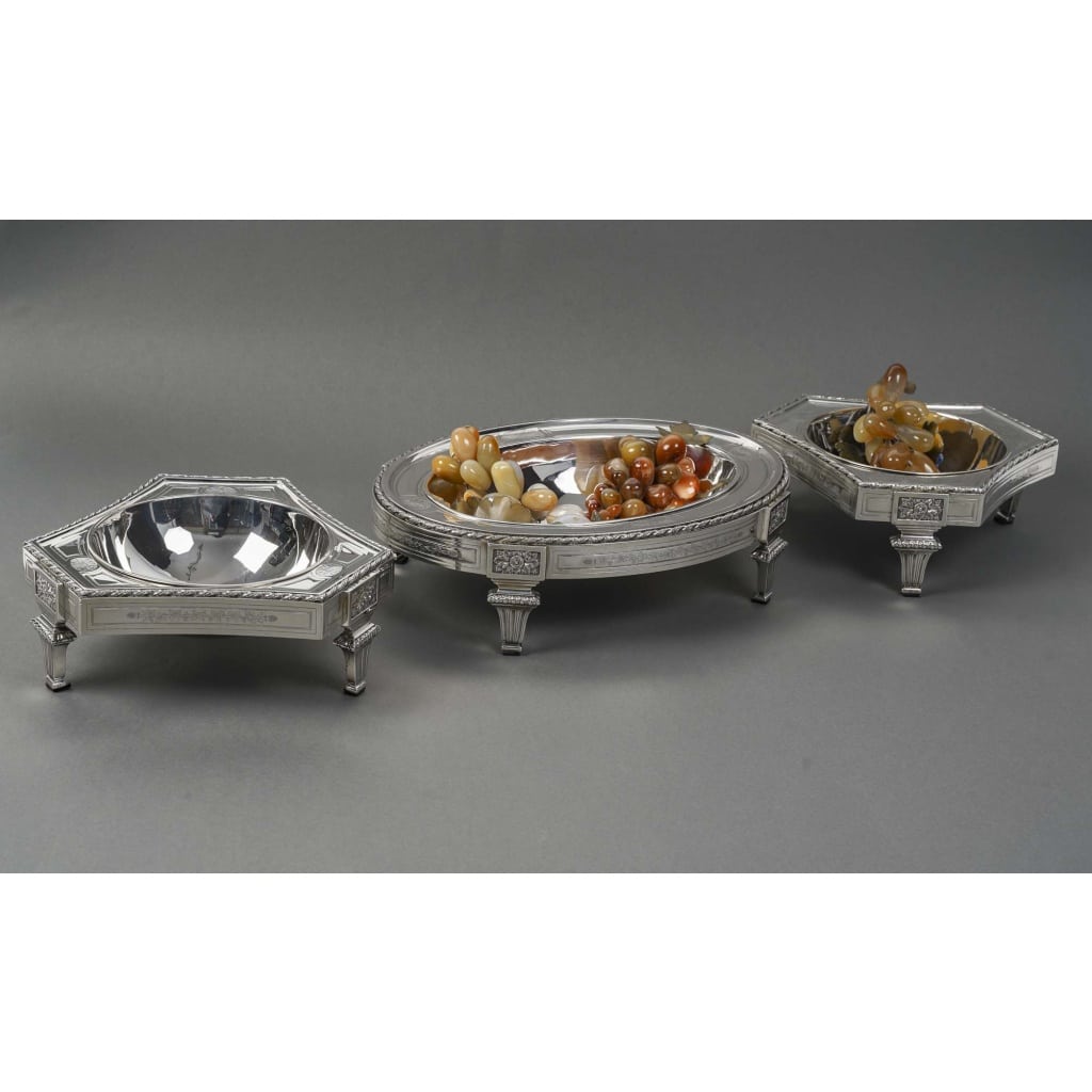 BOIN TABURET – CENTRE DE TABLE EN TROIS PARTIES ARGENT MASSIF FIN XIXe | Biron BOIN TABURET – CENTRE DE TABLE EN TROIS PARTIES ARGENT MASSIF FIN XIXe Centre de table en argent massif à décor néoclassique composé de deux jardinières triangulaires à côtes cintrées et d’une jardinière ovale, chacune reposant sur des pieds pilastres à cannelures. doublures d'origine en métal argenté BOINTABURET Dimensions : Jardinière ovale L 366 cm- P 26 cm- H 9,8 cm Jardinières triangulaires L 26 cm – P 23 cm – H 9,5 cm Matière : Argent 1er titre 950/1°°° Poids : 4 434 grammes NET Poinçon : MINERVE Epoque : FIN XIXè Orfèvre : BOIN TABURET Origine : France/Paris