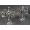 Orfèvre TETARD – Paire de Candélabres 5 lumières en argent massif XXe | Biron Orfèvre TETARD – Paire de Candélabres 5 lumières en argent massif XXe Paire de candélabres en argent massif, base ronde à doucine surmontée d’un fût à pans octogonaux supportant un bouquet à quatre bras de lumière plus une centrale. La base, le fût et les binets sont gravés et ciselés d’un décor à la Bérain dans le style «Régence ». Dimensions : Hauteur 33 cm – entraxe 35 cm Matière : Argent 1er titre 950/1°°° Poids : 4 240 grammes Poinçon : MINERVE Epoque : XXè vers 1925 Orfèvre : TETARD à PARIS Origine : France/Paris