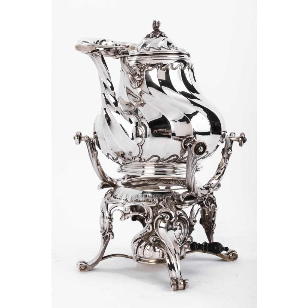 Orfèvre MARTIN Marie Vve – Samovar rocaille en argent massif XIXe | Biron Orfèvre MARTIN Marie Vve - Samovar rocaille en argent massif XIXe Samovar en argent composé d'un support à quatre pieds à enroulement soutenant un bruleur manche ébène surmonté d' une importante verseuse à côtes torses décorée de vagues et de feuillage. anse et bec verseur torsadés Dimensions : hauteur 33 cm - hauteur totale avec anse 40 cm diametre : 24 cm Poids : 2045 grammes Matière : argent Poinçon : Minerve Epoque : XIXè Orfèvre ; MARTIN Marie Vve 1886 ( une cloche une étoile) Origine : France