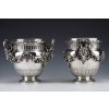 BOIN TABURET – Paire de Rafraichissoirs argent massif Louis XVI – XIXe | Biron BOIN TABURET - Paire de Rafraichissoirs argent massif Louis XVI - XIXe Paire de Rafraichissoirs en argent massif montés sur piédouche, gravés d’un décor de feuilles d’eau, à mi-corps une grosse guirlande de feuilles de laurier est reliée aux anses figurées par des têtes béliers surmontées d’une prise en forme d’anneau. Au col, une large rangée d’arceaux est bordée d’une frise de feuilles de laurier. Int2rieur en métal argenté. Dimensions : hauteur 23 cm – largeur aux anses 27 cm – diamètre col 20 cm – diamètre base 12 cm Matière : Argent 1er titre 950/°°° Poids : 6440 grammes Poinçon : MINERVE Epoque : XIXe vers 1880 Orfèvre : BOIN TABURET Origine : France/PARIS