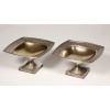 GORHAM – Paire de Coupes en argent massif martelé Birmingham XXe | Biron GORHAM – Paire de Coupes en argent massif martelé Birmingham XXe Très belle paire de coupes en argent martelé montée sur une base carrée à décor de festons surmontée d’un fût supportant une coupe mi creuse vermeillée, bordée d’une ciselure d’ogives fleuries ponctuées de gerbes de blé, le tout dans une forme carrée légèrement arrondie. Dimensions : hauteur 13,5 cm – base 11 cm x11 cm – coupe 24x24 cm Matière : Argent 925/°°° Poids : 1486 grammes Poinçons : Anglais lion passant – ancre Birmingham – N° ordre 1722 Epoque : début XXe Orfèvre : C. CODMAN pour GORHAM Origine : BIRMINGHAM En 1891, l’anglais William C. CODMAN s’est vu confier la responsabilité du département Projets, il créa en 1897 la série « MARTELE ATHENIC » pour la grosse orfèvrerie. En s’inspirant des modèles antiques similaires à nos coupes. La gamme comportait des vases, des coupes, des timbales et des services à thé. La production s’est poursuivie jusqu’en 1910